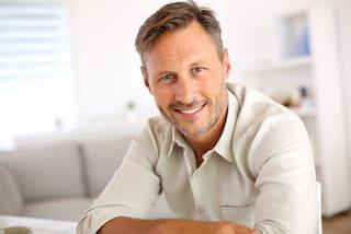 middle-aged man facing forward with bright smile I porcelain veneers at azalea dental
