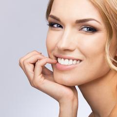 woman smiling with hand resting on chin I clear braces azalea dental