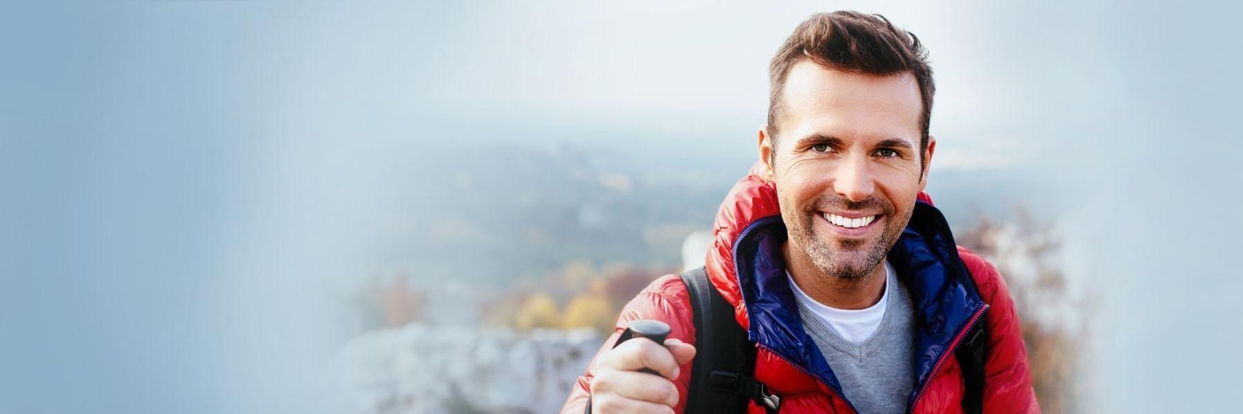 Man hiking & smiling l Tooth Extraction Summerville SC