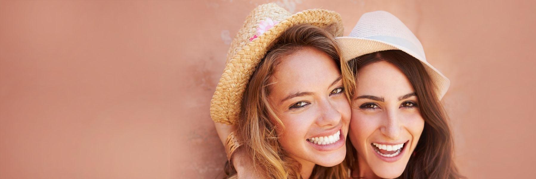 Two young women hugging & smiling l General dentist Summerville SC